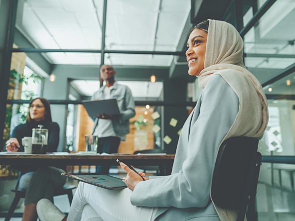 a woman in a office meeting wearing a hijab